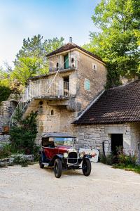 una vecchia auto parcheggiata di fronte a un edificio di Le Domaine des Carriers - Gites a Chevroches