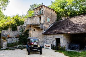 une vieille voiture garée devant un bâtiment dans l'établissement Le Domaine des Carriers - Gites, à Chevroches