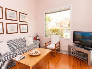 a living room with a couch and a television at Bungalow Marina Deluxe in Pasito Blanco