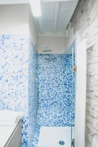 y baño con ducha de azulejos azules. en Piccolo girasole, en Perugia