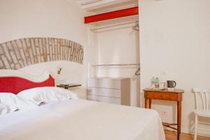 una camera con letto bianco e testiera rossa di Piccolo girasole a Perugia