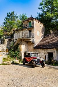 une vieille voiture garée devant un bâtiment dans l'établissement Le Domaine des Carriers - Gites, à Chevroches