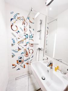 Baño blanco con lavabo y espejo en Hotel Favorit, en Venus