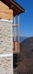 a balcony of a house with mountains in the background at Graziosa, Casetta in Valgerola in Rasura