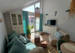 a living room with a couch and a tv at Rajski Zakątek in Żarnowska