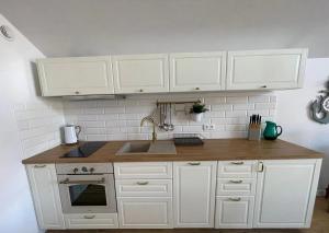 a kitchen with white cabinets and a sink at Rajski Zakątek in Żarnowska