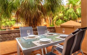 uma mesa e cadeiras numa varanda com palmeiras em Lovely Apartment In Los Alczares With Kitchen em Los Alcázares