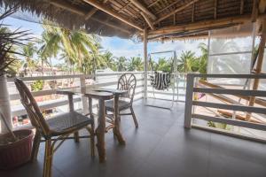 een tafel en stoelen op een balkon met uitzicht op de oceaan bij 8 Colors Beach House Resort in Boracay