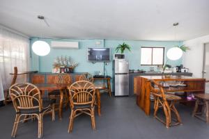 uma cozinha e sala de jantar com mesas e cadeiras de madeira em 8 Colors Beach House Resort em Boracay