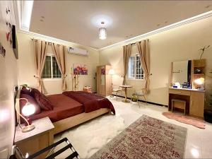 a bedroom with a bed and a desk in it at الجوهرة الزرقاء بجوار قرية السماء - سما أبها in Abha