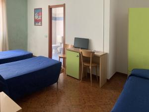 pokój z dwoma łóżkami i biurkiem z komputerem w obiekcie Aquila Nera Di Tony w mieście Ivrea