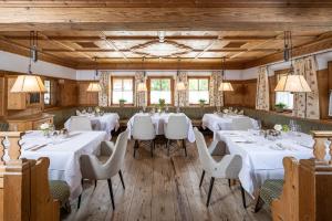 a dining room with white tables and chairs at Der Böglerhof - pure nature resort in Alpbach