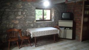 a room with a table and chairs and a tv at Vila Lapušnja - najam cele vikendice in Krivi Vir