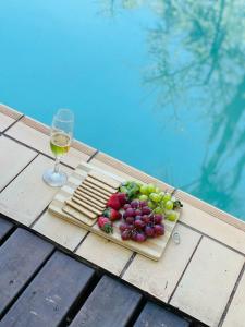 um prato de uvas e um copo de vinho numa mesa em Harnham Mountain Lodge em Louis Trichardt