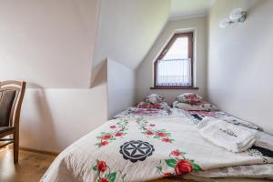 a bedroom with a bed with a comforter and a window at Pokoje u Borzana in Biały Dunajec