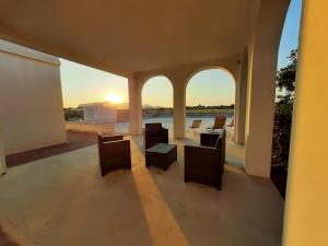 a room with chairs and a view of the sunset at Gli Archi residence CalaAzzurra in Favignana