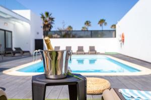 un cubo con una botella de champán junto a la piscina en Villa Luxury Azul Private Pool and BBQ Corralejo By Holidays Home, en Corralejo