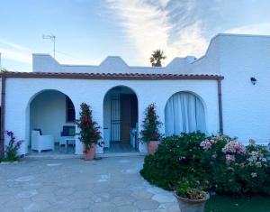 a white house with a porch and a patio at Villetta Martino Guest House in Torre Chianca