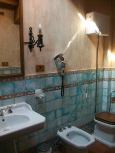 a bathroom with a sink and a toilet and a light at Tenuta Vento di Mare in Lido Di Fondi