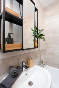 Un baño con un lavabo blanco y un espejo. en New & cozy studio in Ghencea + Netflix, en Bucarest