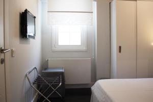 a small bedroom with a bed and a window at 19 Oda Bozcaada in Çanakkale