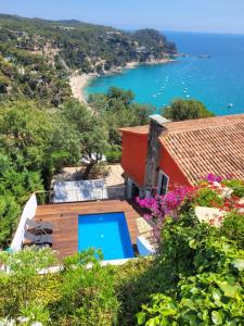 a house with a swimming pool and a view of the ocean at Boutique Villa Panorama in Tossa de Mar