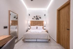 una camera con un letto e un grande specchio di Marea Boutique Suites a Rethymno