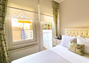 a bedroom with a white bed and a window at 19 Oda Bozcaada in Çanakkale