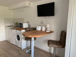 a small kitchen with a table and a microwave at Studio calme, la campagne a 5 minutes de la ville in Fondettes