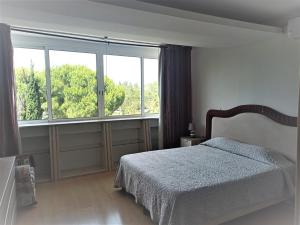a bedroom with a bed and a large window at Parque das Amendoeiras in Vilamoura +46 photos