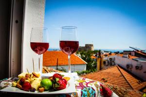two glasses of wine and a plate of fruit on a table at 19 Oda Bozcaada in Çanakkale