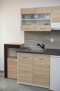 a kitchen with wooden cabinets and a sink at Lakki Village in Aegiali