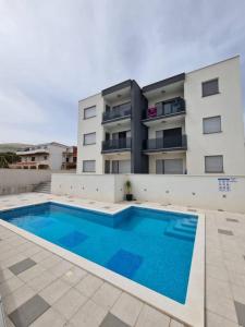 una grande piscina di fronte a un edificio di West Star Apartment a Trogir