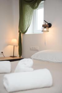 a bedroom with a bed with a window and a lamp at Lakki Village in Aegiali