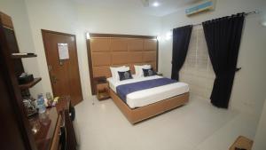 - une chambre avec un grand lit dans l'établissement Four Squares Karachi, à Karachi