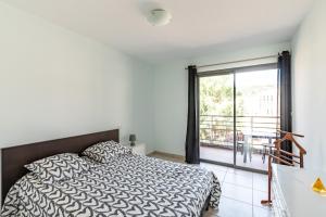 1 dormitorio con 1 cama y balcón en Calvaro - Appartement classé 5 étoiles - vue mer, en Calvi