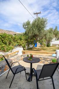 a patio with two chairs and a table with a table at Lakki Village in Aegiali
