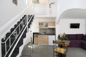 a living room with a purple couch and a staircase at Lakki Village in Aegiali