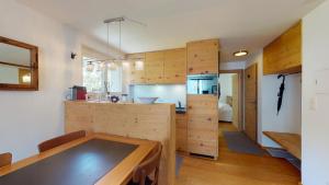 eine Küche mit Holzschränken und einem Tisch im Zimmer in der Unterkunft Abitaziun Chatrigna 5 - Celerina in Celerina