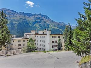 a large white building with mountains in the background at Abitaziun Sur Ovel - St Moritz "LOGA ELEGANCE APARTMENT" in St. Moritz