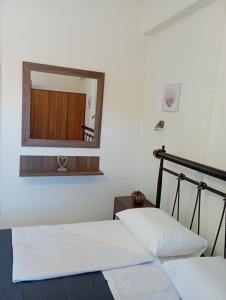 Schlafzimmer mit einem Bett und einem Spiegel in der Unterkunft Sofirene I in Batsi