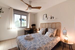 um quarto com uma cama com um edredão azul e uma janela em Guilhermy - Maison contemporaine avec jardin em Toulouse