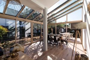 a conservatory with glass walls and a table and chairs at Guilhermy - Maison contemporaine avec jardin in Toulouse