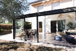 a glass extension of a house with a patio at Guilhermy - Maison contemporaine avec jardin in Toulouse