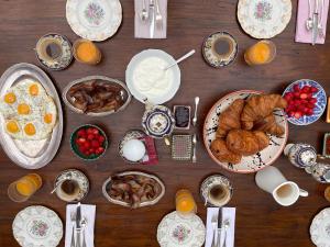 a wooden table topped with plates of breakfast foods at La Maison Uhabia in Bidart