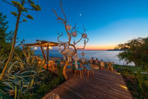 a wooden deck with chairs and tables and the ocean at Liberty Lykia in Oludeniz