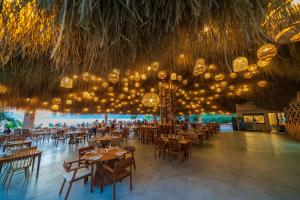 a dining room with tables and chairs and chandeliers at Liberty Lykia in Oludeniz