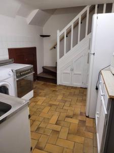 a kitchen with white appliances and a wooden floor at Maison chaleureux in Coulanges-sur-Yonne