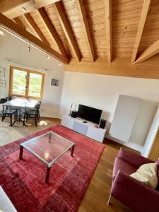 sala de estar con mesa y alfombra roja en Mischabelblick en Fiesch