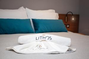 a white towel sitting on top of a bed at Lithos Suites - Nikiti Halkidiki in Nikiti